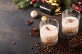 Glass of Irish cream baileys liqueur with ice, roasted coffee beans, cinnamon, Christmas decoration and chocolate on dark wood Royalty Free Stock Photo