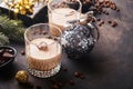 Glass of Irish cream baileys liqueur with ice, roasted coffee beans, cinnamon, Christmas decoration and chocolate on dark wood Royalty Free Stock Photo