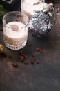 Glass of Irish cream baileys liqueur with ice, roasted coffee beans, cinnamon, Christmas decoration and chocolate on dark wood Royalty Free Stock Photo