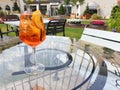 A glass of Italian cocktail Spritz stands on a glass table on the terrace Royalty Free Stock Photo