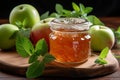 Glass jar Apple jam, two apples, green mint on wooden background