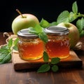 Glass jar Apple jam, two apples, green mint on wooden background