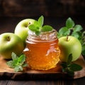 Glass jar Apple jam, two apples, green mint on wooden background
