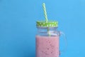 Glass jar of blackberry smoothie isolated on a blue background Royalty Free Stock Photo