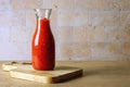 Glass jar bottle with homemade tomato sauce stands on cutting board Royalty Free Stock Photo