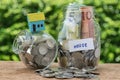 glass jar bottle labeled as house with full of coins and miniature house on as home, property or mortgage investment concept Royalty Free Stock Photo