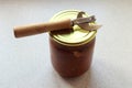 Glass jar with canned food and a can opener on the kitchen table, top view, space for text Royalty Free Stock Photo