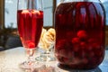 The glass jar of cherry compote, a glass with compote, sweets in a vase, close up Royalty Free Stock Photo