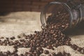 Glass jar with coffee beans scattered on the table Royalty Free Stock Photo