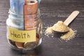 Glass jar with coins and euro banknotes with the inscription HEALTH. A handful of germinated wheat seeds Royalty Free Stock Photo