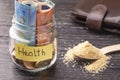 Glass jar with coins and euro banknotes with the inscription HEALTH. A handful of germinated wheat seeds Royalty Free Stock Photo