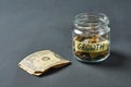 Glass jar with coins and inscription growth near banknote of one dollar