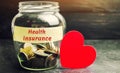 Glass jar with coins and the inscription `Health Insurance`. The concept of medical insurance of life, family, health. Healthcare. Royalty Free Stock Photo