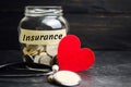 Glass jar with coins and the inscription `Insurance`. The concept of medical insurance of life, family, health. Healthcare. Red he Royalty Free Stock Photo