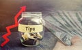 Glass jar with coins and the inscription ` Tips ` and up arrow. Award for good service in the cafe and restaurant. High level of s Royalty Free Stock Photo