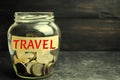 Glass jar with coins and the inscription `travel`. concept of saving and collecting money on travel. Budget for vacation and resor Royalty Free Stock Photo