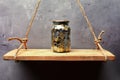 Glass jar with coins on the old wood shelf Royalty Free Stock Photo