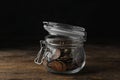 Glass jar with coins on table Royalty Free Stock Photo