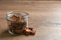 Glass jar with coins on wooden table, space for text. Royalty Free Stock Photo