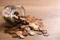 Glass jar with coins on wooden table, space for text. Royalty Free Stock Photo