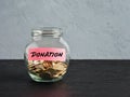 Glass jar with coins and the word donation on a label. Charity, aid, assistance, collecting donations and financial contribution