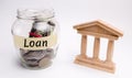 Glass jar with coins and the word Loan and a state building. Borrow money, Take a loan or a credit from a bank. Deposit concept. Royalty Free Stock Photo