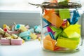 Glass jar with colored notes with blur and toning. Royalty Free Stock Photo