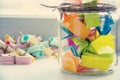 Glass jar with colored notes with blur Royalty Free Stock Photo