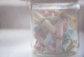 Glass jar with colored notes with blur and toning. Royalty Free Stock Photo