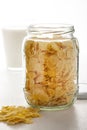 Glass jar of corn flakes with mug of milk