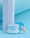 Glass Jar with cosmetic cream on a blue background. Composition with geometric shapes. Cosmetic products