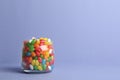 Glass jar with delicious bright jelly beans on color background Royalty Free Stock Photo