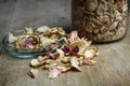 a glass jar with dried yellow and pink rose petals on a wooden table Royalty Free Stock Photo