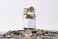Glass jar filled with coins on a group of coins. Royalty Free Stock Photo