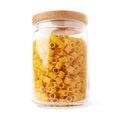 Glass jar filled with dry ditalini pasta over isolated white background