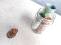 Glass Jar Filled With Euro Banknotes and Coins on Table. Concept of savings ranging from small money to large Royalty Free Stock Photo