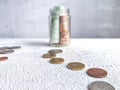 Glass Jar Filled With Euro Banknotes and Coins on Table. Concept of savings ranging from small money to large Royalty Free Stock Photo