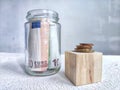 Glass Jar Filled With Euro Banknotes and Coins on Table. Concept of savings ranging from small money to large Royalty Free Stock Photo