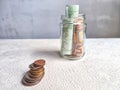 Glass Jar Filled With Euro Banknotes and Coins on Table. Concept of savings ranging from small money to large Royalty Free Stock Photo