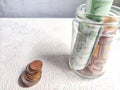 Glass Jar Filled With Euro Banknotes and Coins on Table. Concept of savings ranging from small money to large Royalty Free Stock Photo