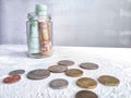 Glass Jar Filled With Euro Banknotes and Coins on Table. Concept of savings ranging from small money to large Royalty Free Stock Photo