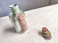 Glass Jar Filled With Euro Banknotes and Coins on Table. Concept of savings ranging from small money to large Royalty Free Stock Photo