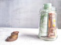 Glass Jar Filled With Euro Banknotes and Coins on Table. Concept of savings ranging from small money to large Royalty Free Stock Photo