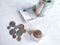 Glass Jar Filled With Euro Banknotes and Coins on Table. Concept of savings ranging from small money to large Royalty Free Stock Photo