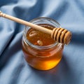 A glass jar filled with golden honey is placed on a light blue Royalty Free Stock Photo