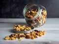 Glass jar filled with healthy nuts, seeds and raisins spilling out, the perfect health fat and good carbohydrate to provide Royalty Free Stock Photo