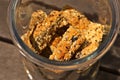 Glass jar filled with homemade rusks on a wooden surface