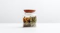 a glass jar filled with layers of dried herbs and flowers on a white background