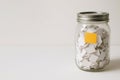 A glass jar filled with many white paper cards. Space for text. Royalty Free Stock Photo