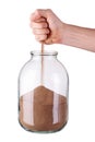 Glass jar with fist and sand on white background Royalty Free Stock Photo